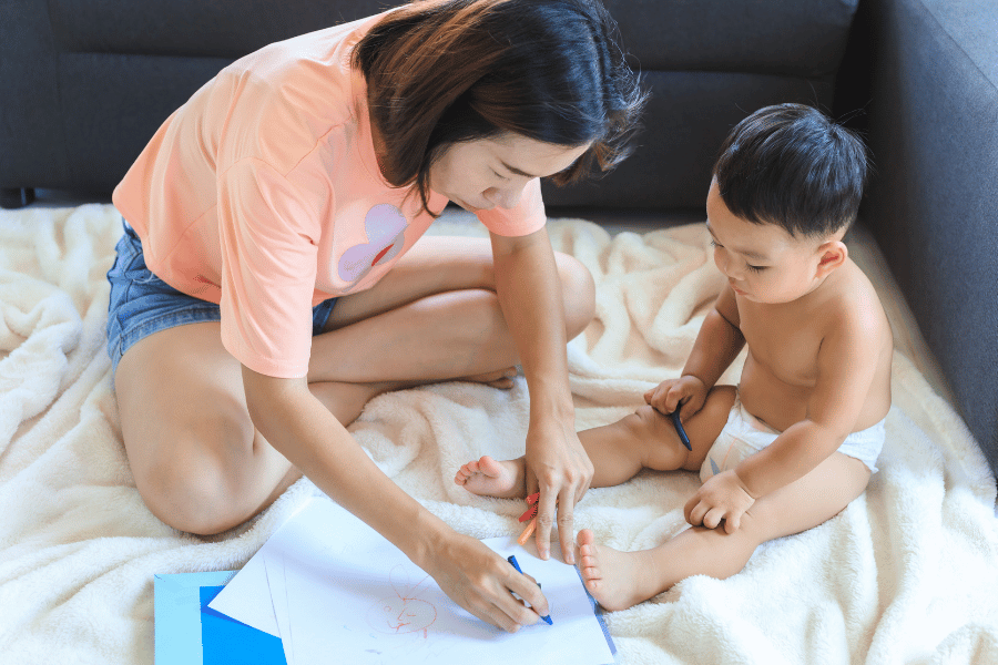 妈妈陪着小宝宝在床上画画——比起教孩子画得好，温柔陪伴的瞬间更能建立孩子的安全感